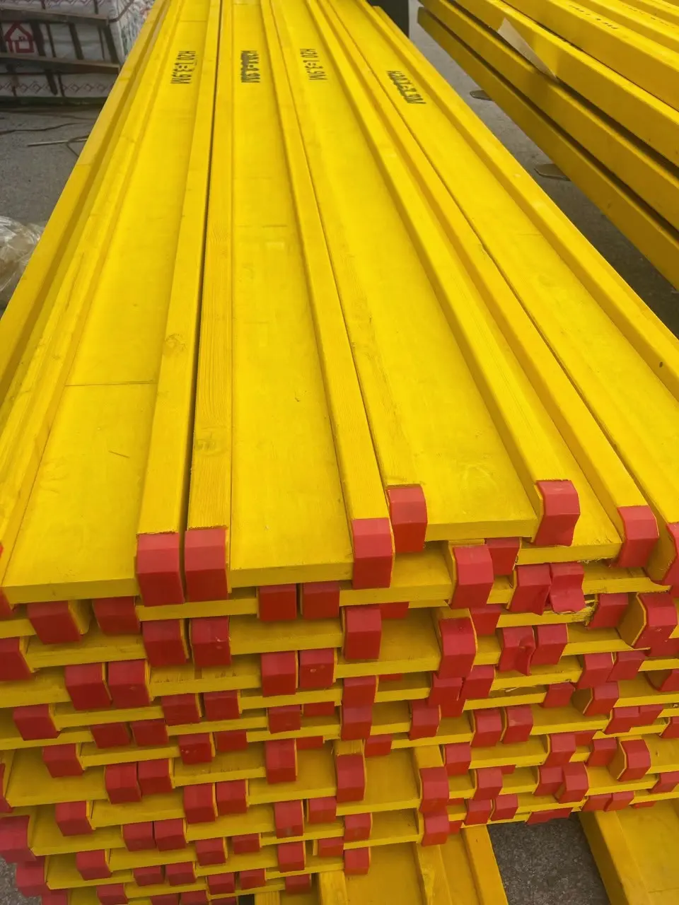 H20 timber beams with red end caps stacked in the yard