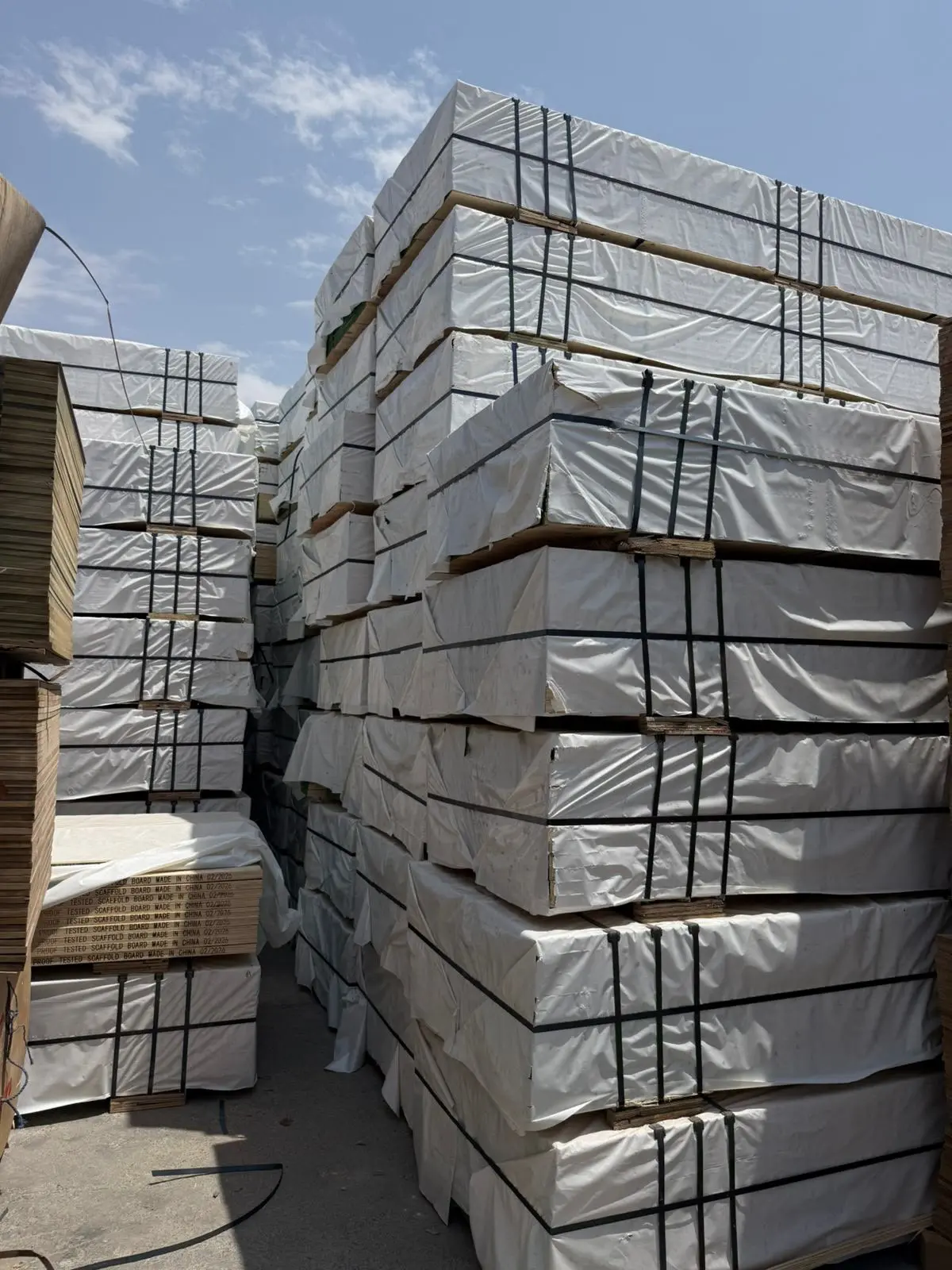 Wrapped LVL board bundles stacked outdoors