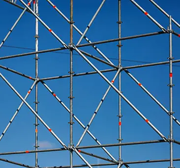 Scaffolding lattice erected against a clear sky